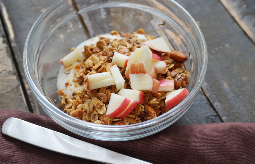 Homemade Granola with Almonds in a glass bowl with spoon
