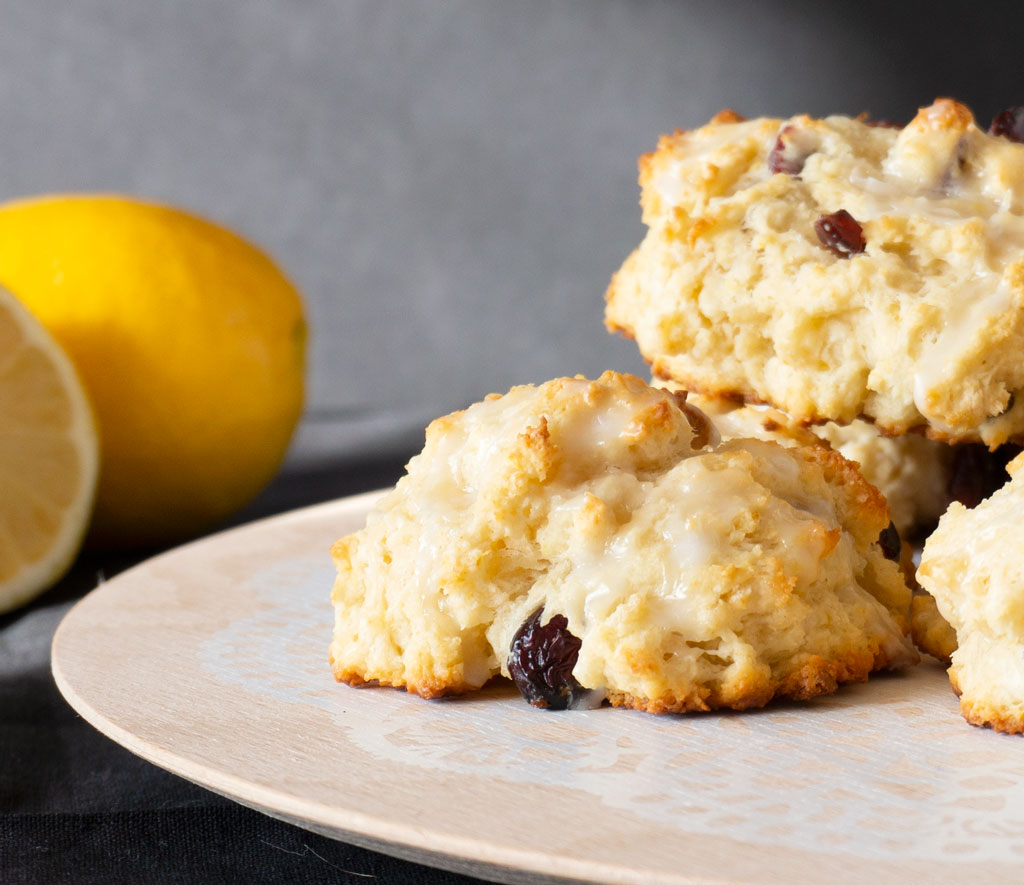 lemon cranberry scone on plate with lemons in background