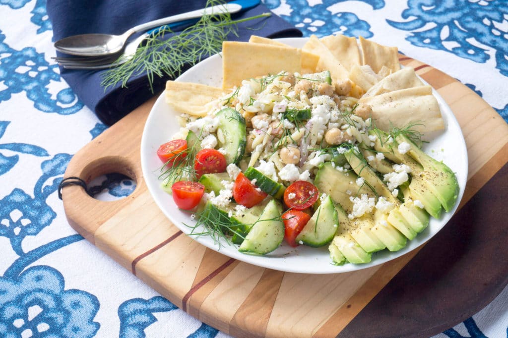 Mediterranean Orzo Salad on plate with blue tablecloth