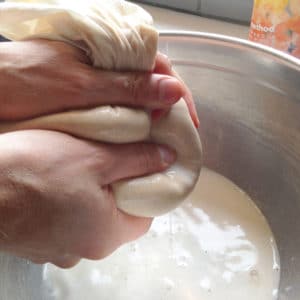 squeezing homemade nut milk