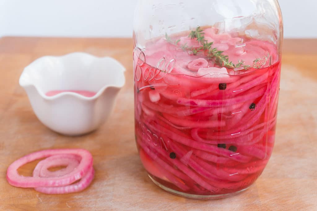 pickled red onions in jar side view