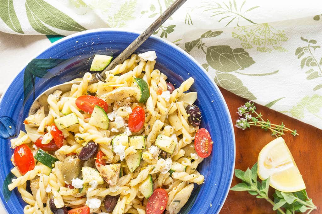 overhead view of greek pasta salad in blue bowl