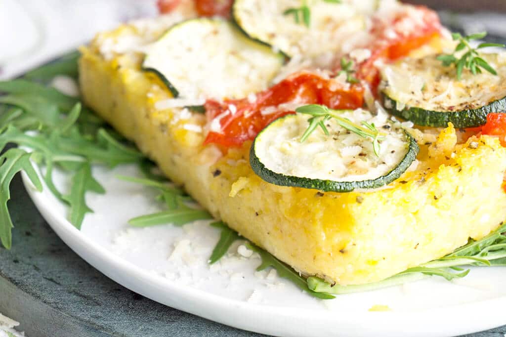 Slice of baked polenta topped with zucchini and tomatoes