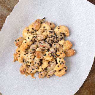 a single Maple Almond Cashew Cluster cookie on parchment paper