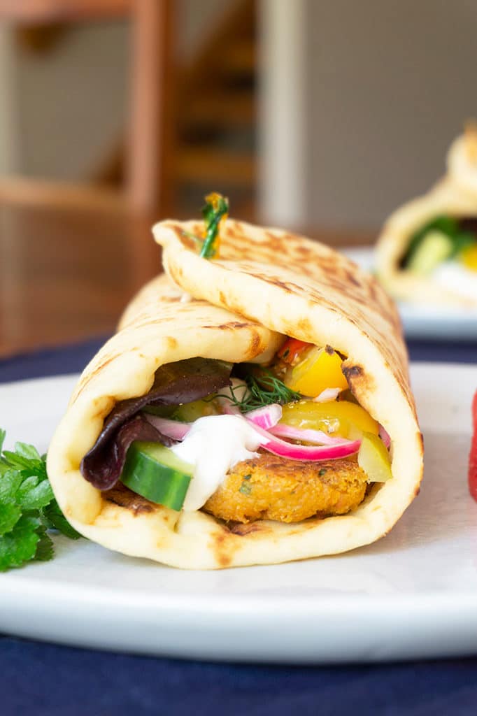 vertical photo of healthy falafel wraps with pickled onion and cucumber