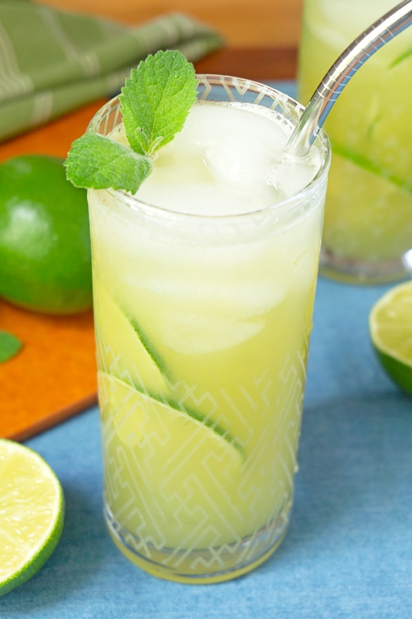 tall glass of cucumber lime water with stainless steel straw