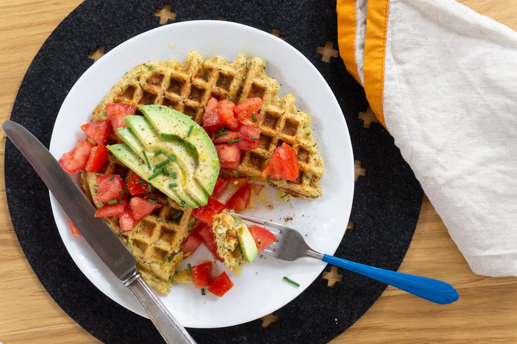 Healthy Waffles with Zucchini on plate with tomatoes and avocado slices