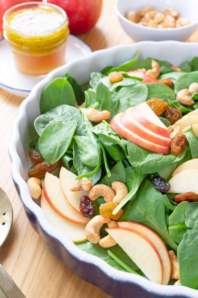 A BRIGHT AND CRISP APPLE SALAD! Packed with spinach, this Apple-Cashew Spinach Salad is dressed with a tangy apple cider vinaigrette and mixed with creamy cashews and sweet apple and raisins. | #AppleRecipes | #AppleSalad | #SaladIdeas | #VegetarianRecipes | #HealthyRecipes at OatandSesame.com #oatandsesame