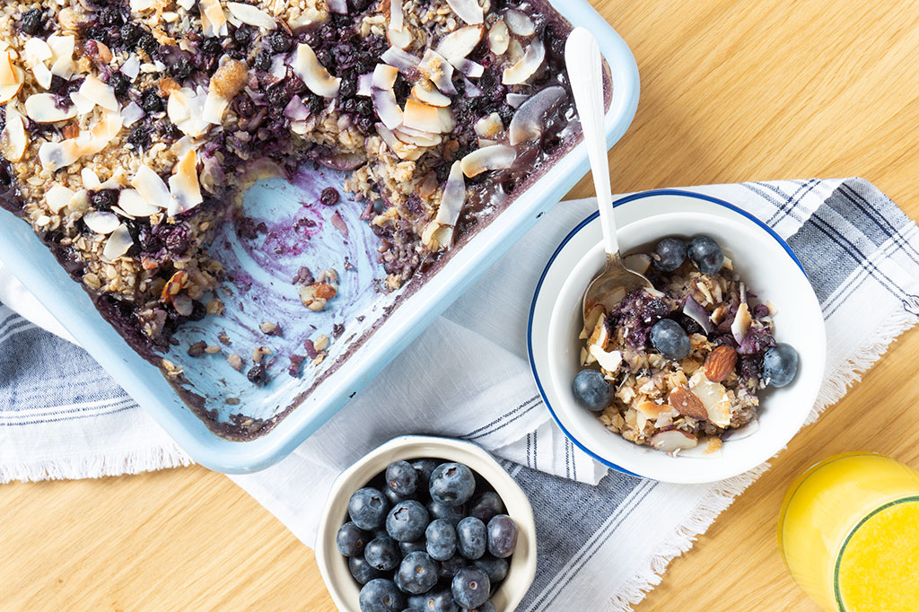 baked oatmeal in pan with bowl of blueberries on the side