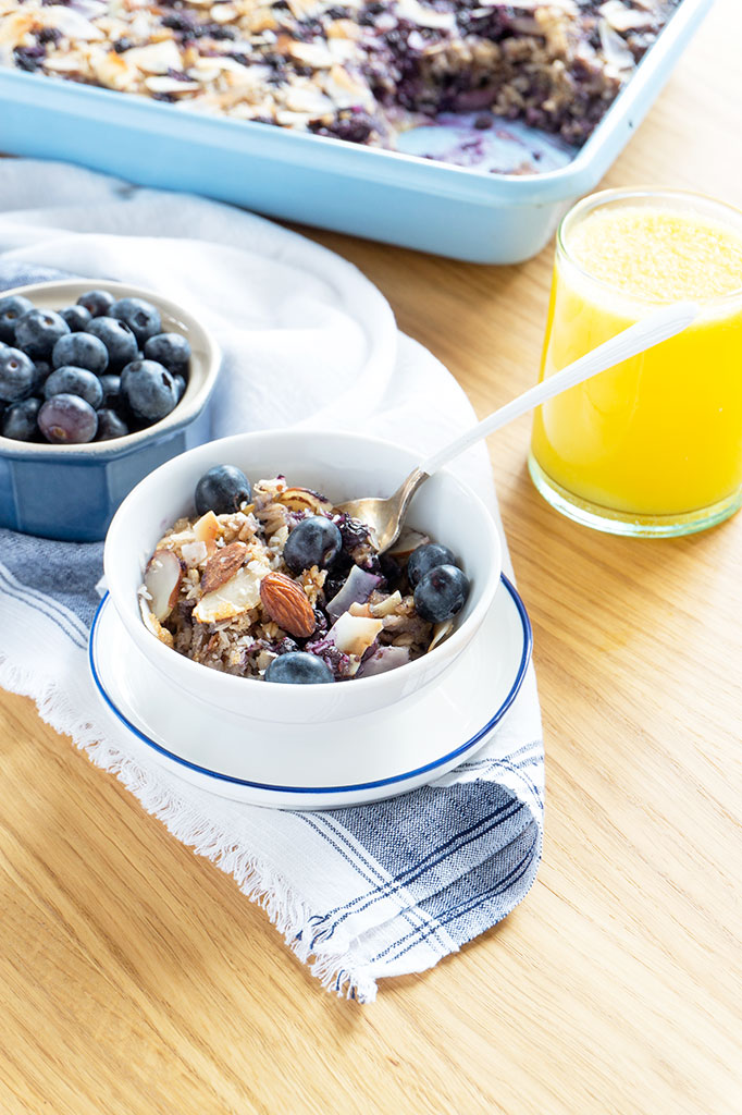 serving oatmeal in bowl with orange juice glass