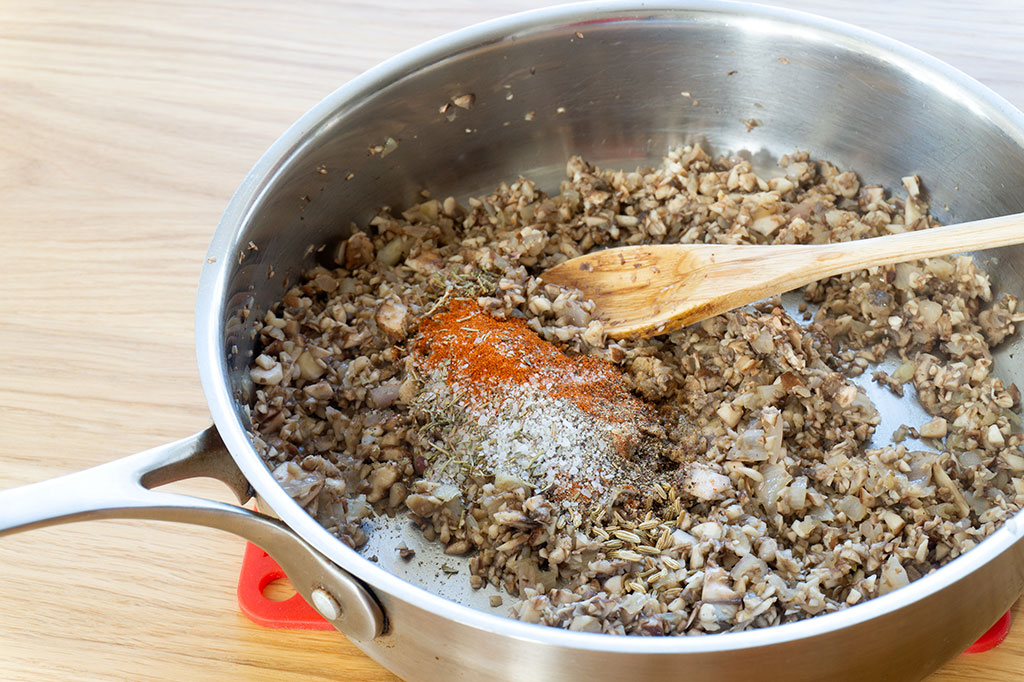 mixing spices into mushrooms