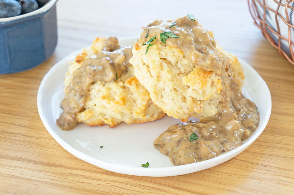 biscuits with mushroom gravy on top served on a plate