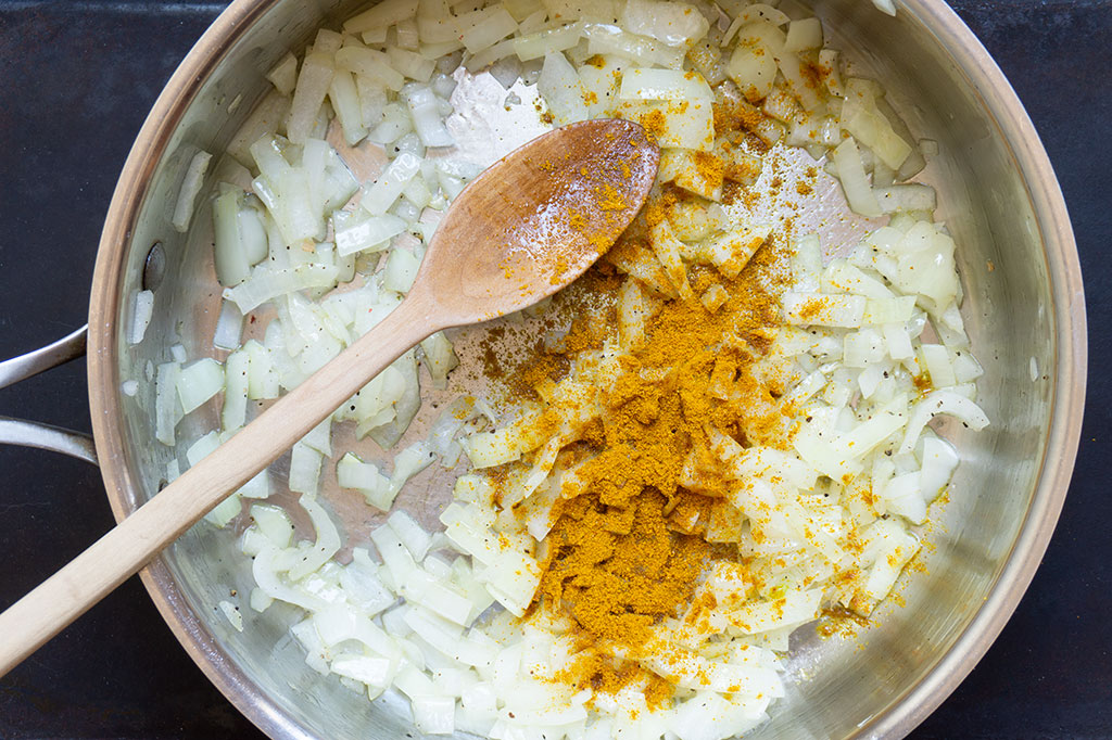 onions in a frying pan with curry powder
