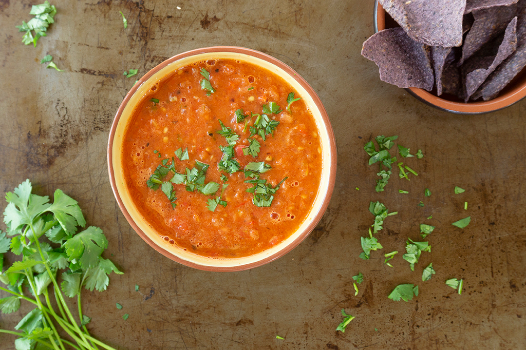 Blender Salsa in bowl with cilantro and chips on side