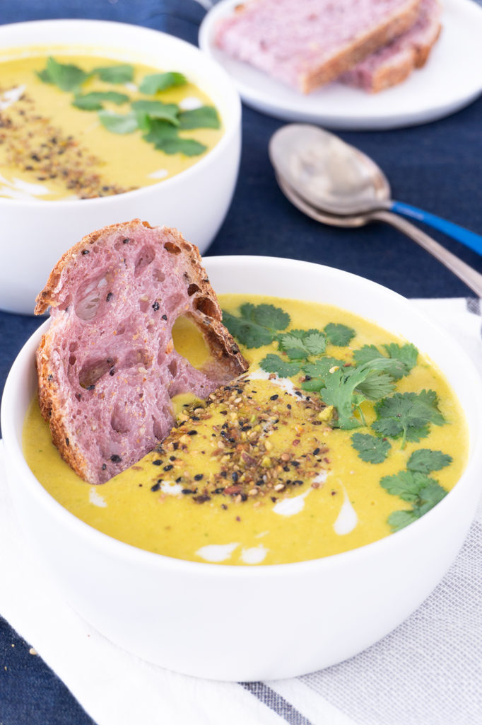 Mulligatawny Soup in a bowl with purple sweet potato sourdough bread