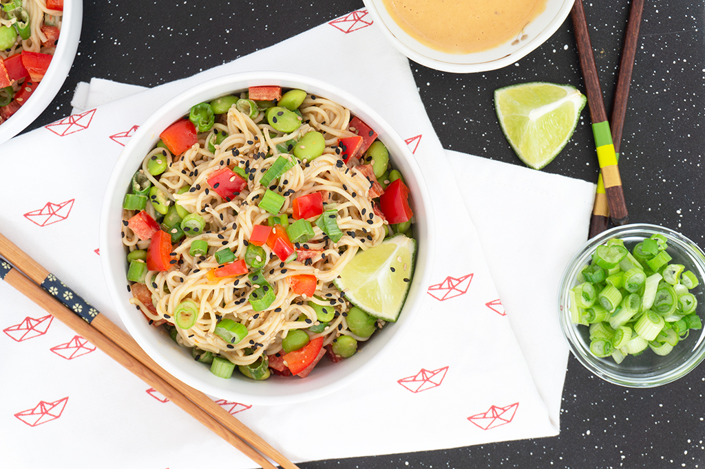 Tahini Noodle Bowl with red peppers and edamame on top overhead view